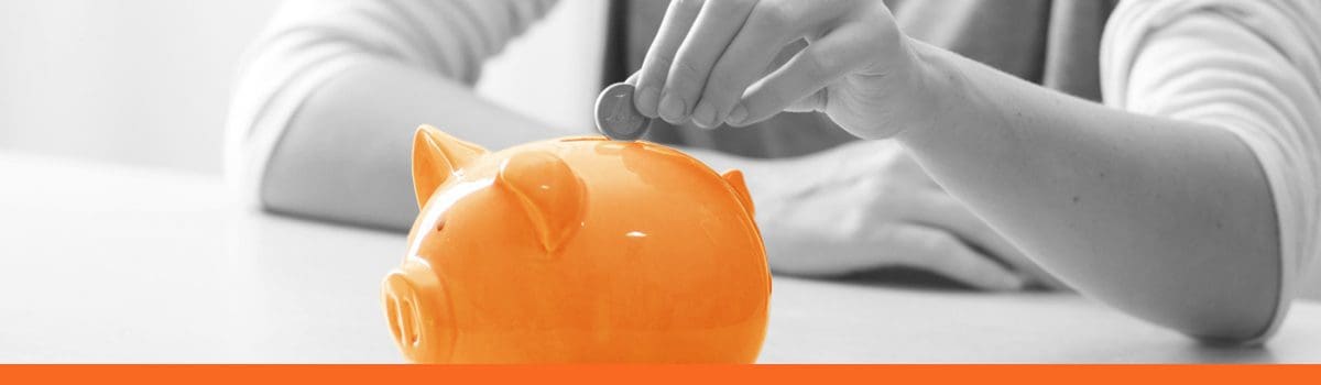 A woman putting a coin in a piggybank