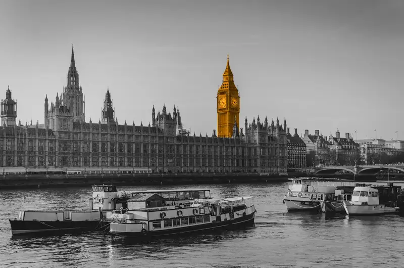 A black and white image of London, with an orange clock tower