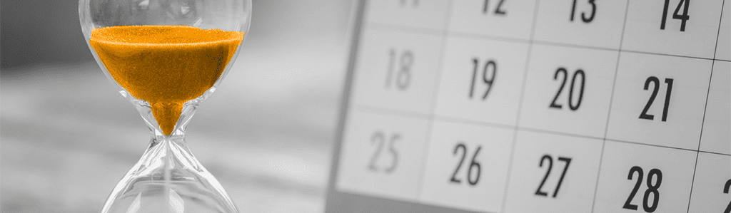 A black and white image of a calendar and hourglass, but the sand is orange