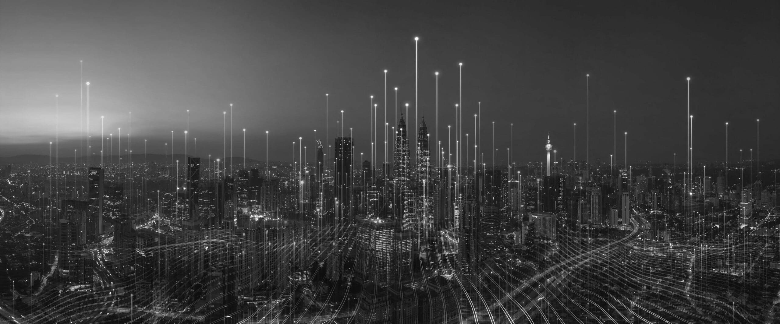 A black and white skyline view of a lot of buildings at night