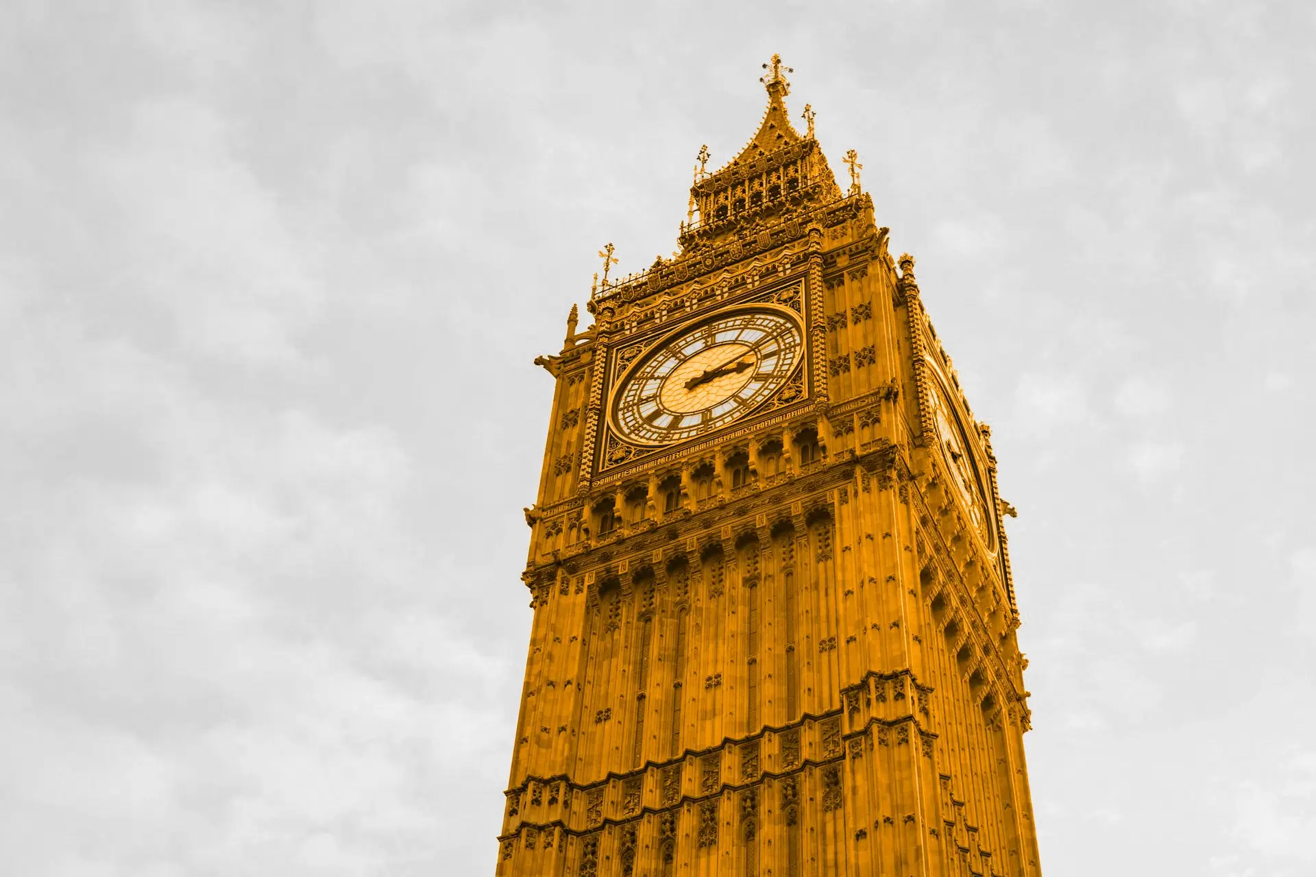 A black and white sky, with an orange clock tower