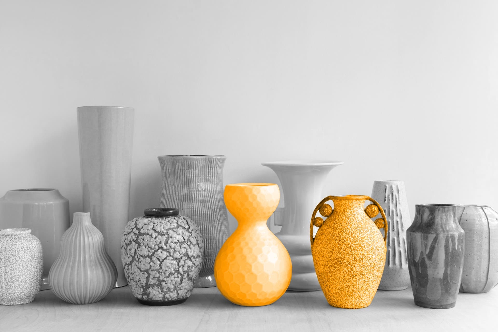 A black and white image of vases, with two of them being orange