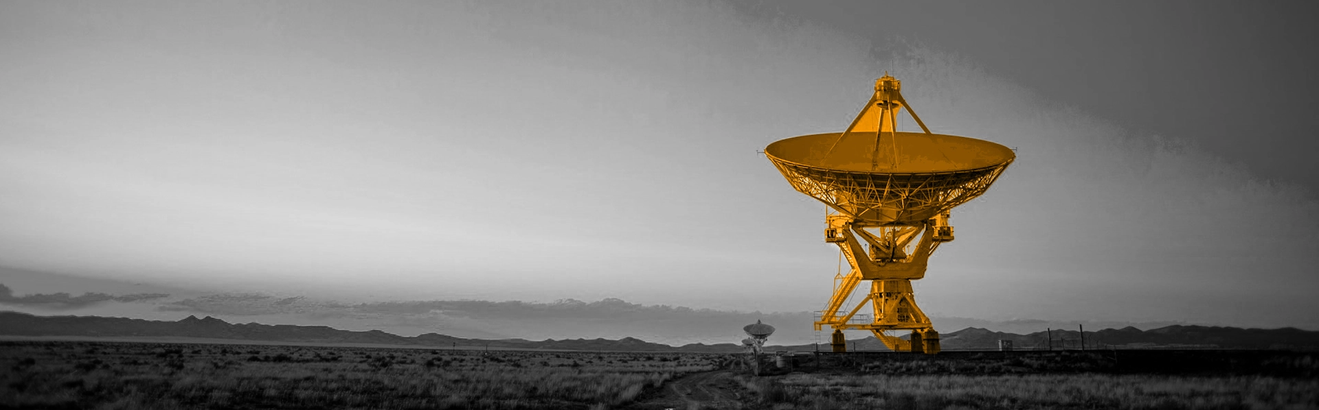 A black and white image of a field, with a giant orange satellite image in the middle